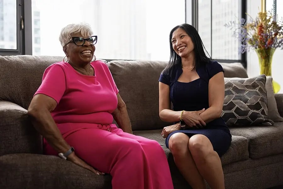 TheKey care advisor meeting with an elderly client at home, sharing a warm conversation about personalized senior home care and family support services